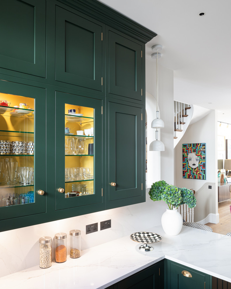 Small eclectic u-shaped kitchen in London with shaker cabinets, green cabinets, quartzite benchtops, white splashback and white benchtop.