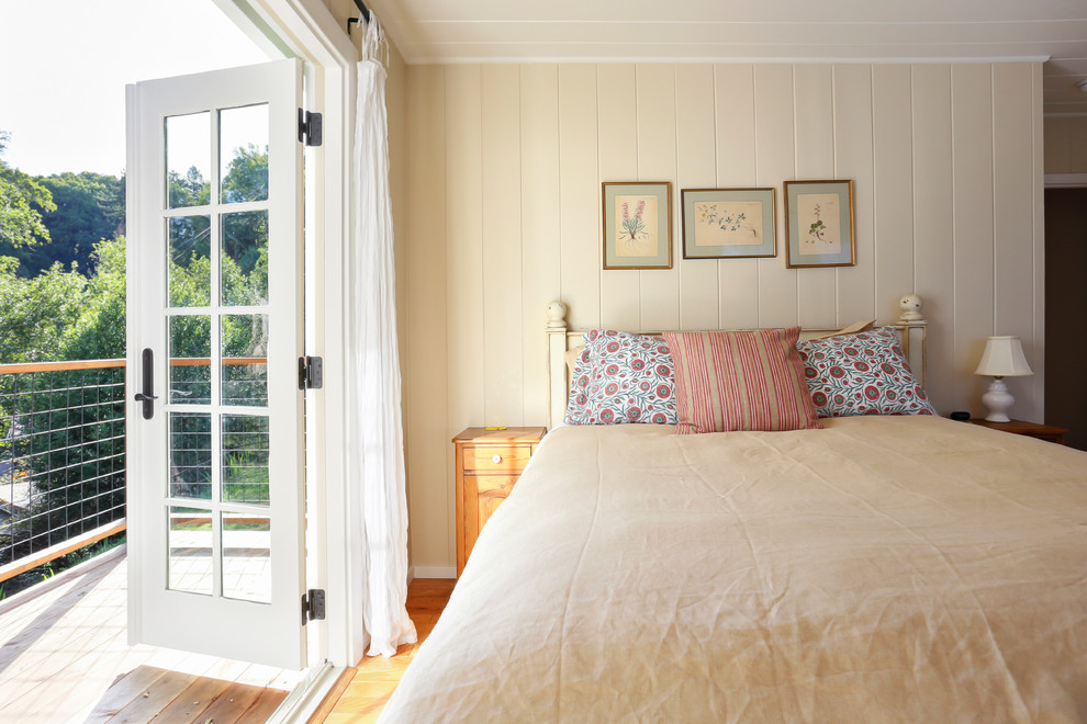 This is an example of a country bedroom in San Francisco with yellow walls, medium hardwood floors and no fireplace.
