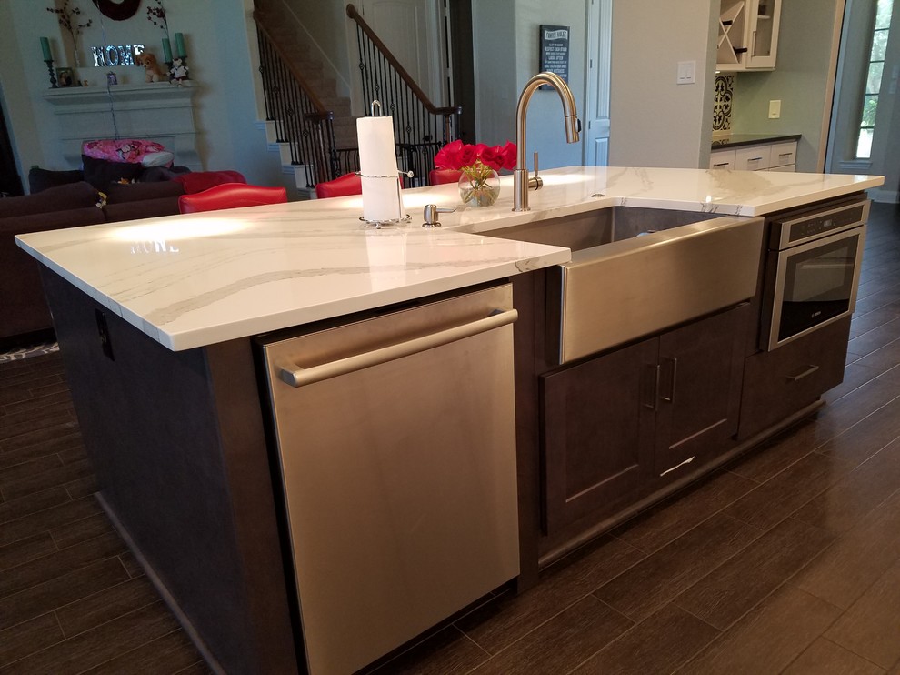 Large transitional l-shaped dark wood floor and brown floor eat-in kitchen photo in Houston with a farmhouse sink, shaker cabinets, white cabinets, quartz countertops, porcelain backsplash, stainless steel appliances, an island and multicolored backsplash