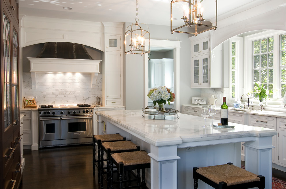 Large traditional u-shaped eat-in kitchen in Chicago with white cabinets, marble benchtops, white splashback, stainless steel appliances, dark hardwood floors, with island, stone tile splashback, an undermount sink and recessed-panel cabinets.