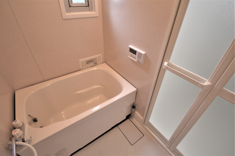 Cette image montre une salle de bain principale design avec un bain bouillonnant, un mur beige, un sol beige et une fenêtre.