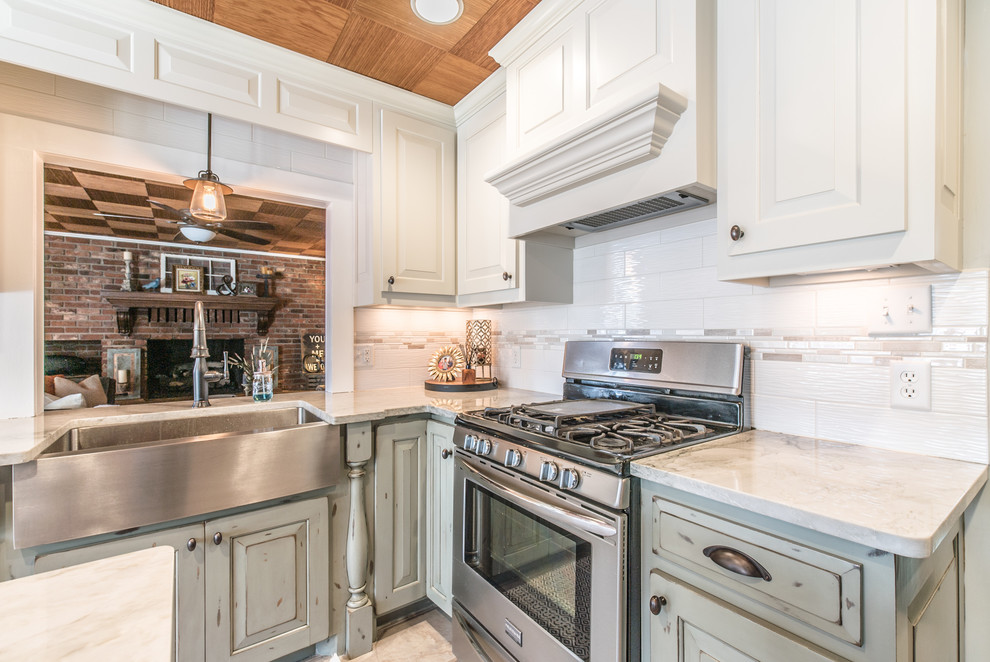 Mid-sized traditional l-shaped eat-in kitchen in Other with a farmhouse sink, quartzite benchtops, white splashback, porcelain splashback, stainless steel appliances and with island.