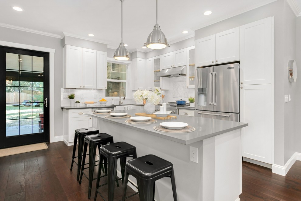 Open concept kitchen photo in Seattle with flat-panel cabinets, white cabinets and an island