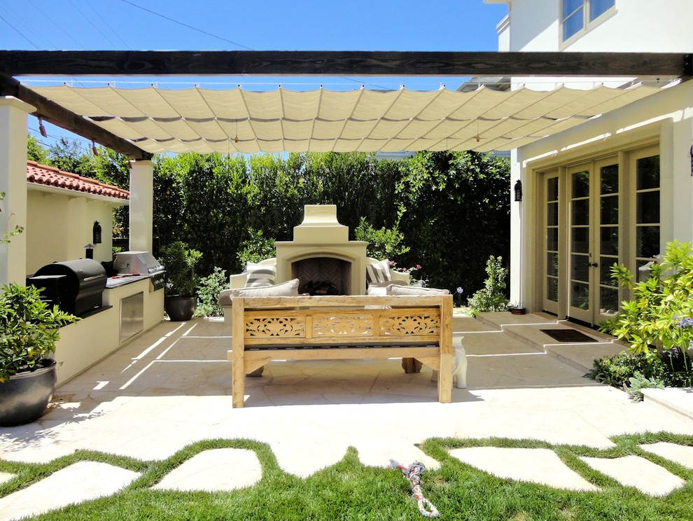 Inspiration for a mediterranean backyard patio in Los Angeles with an awning.