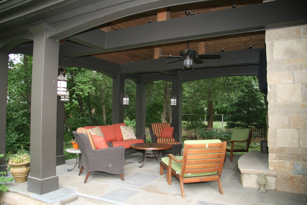Design ideas for a mid-sized traditional backyard patio in Omaha with tile and a roof extension.