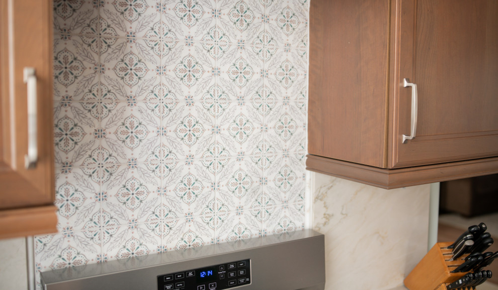 Inspiration for a mid-sized coastal light wood floor eat-in kitchen remodel in Baltimore with recessed-panel cabinets, medium tone wood cabinets, quartzite countertops, stainless steel appliances, an island and white countertops