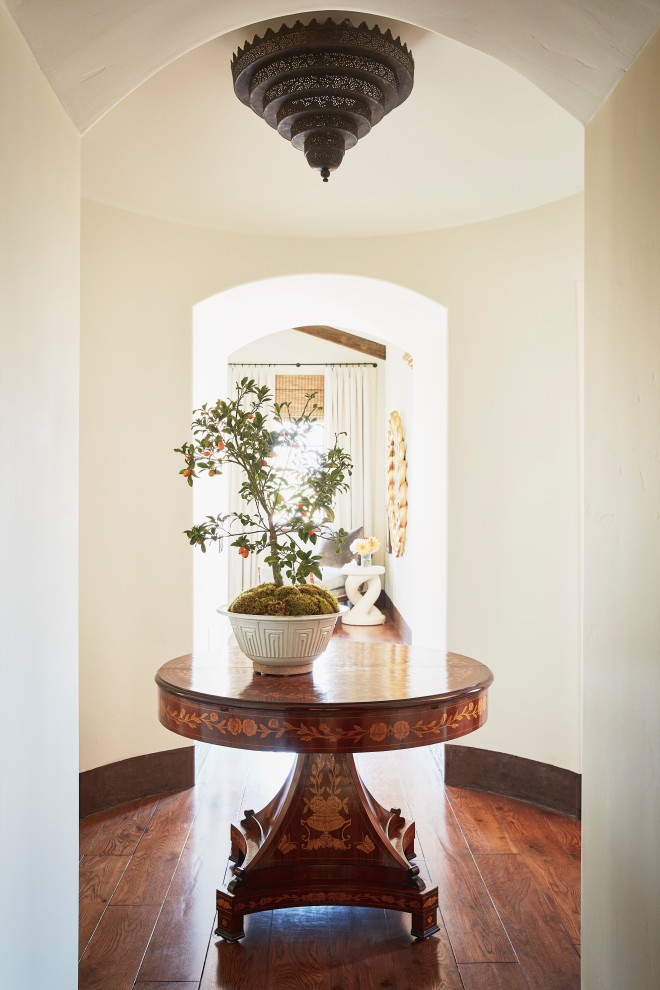 Inspiration for a mediterranean hallway in Los Angeles with beige walls and dark hardwood floors.