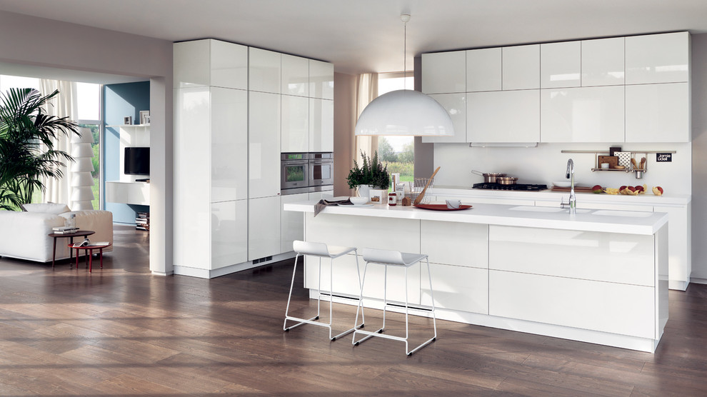 Design ideas for a large modern galley eat-in kitchen in Melbourne with a double-bowl sink, raised-panel cabinets, white cabinets, quartzite benchtops, white splashback, porcelain splashback, panelled appliances, medium hardwood floors and multiple islands.