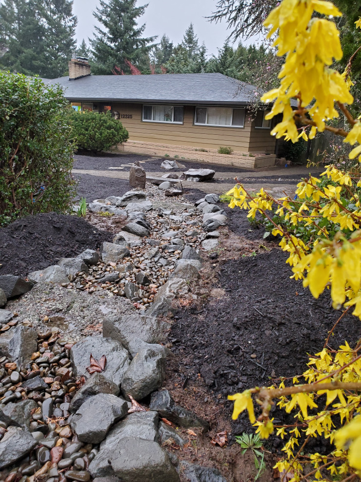 Inspiration for a mid-sized midcentury front yard full sun formal garden in Portland with river rock and with rock feature.