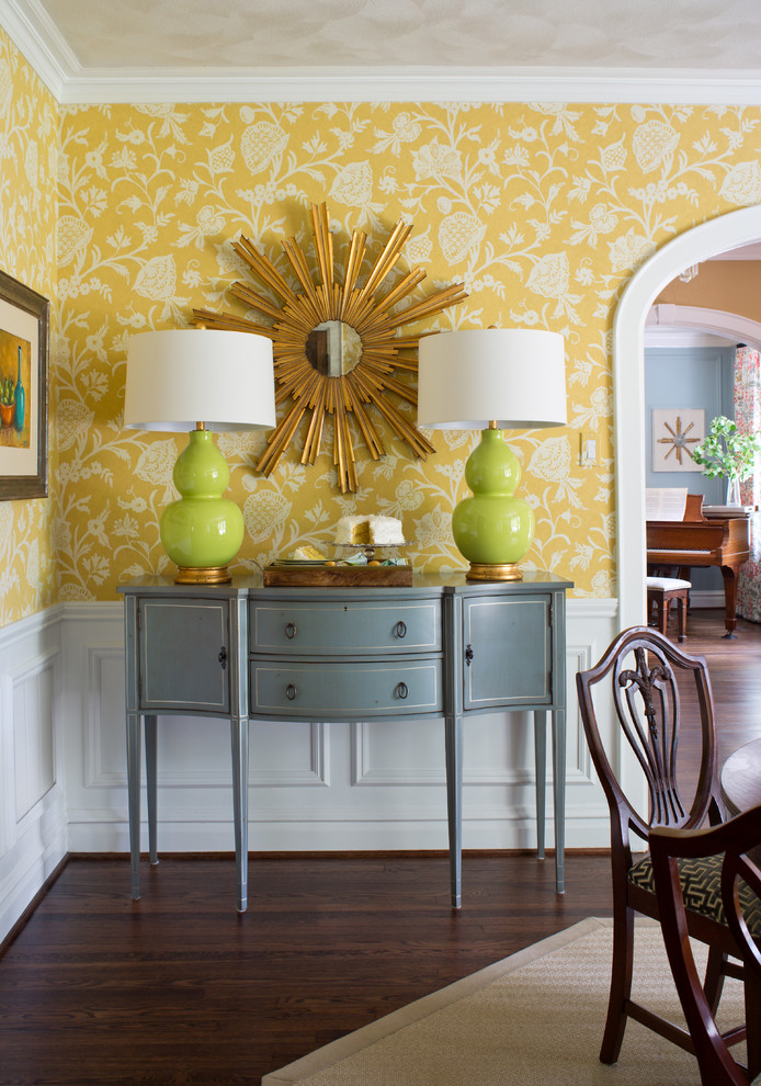 This is an example of a large traditional separate dining room in St Louis with yellow walls and dark hardwood floors.