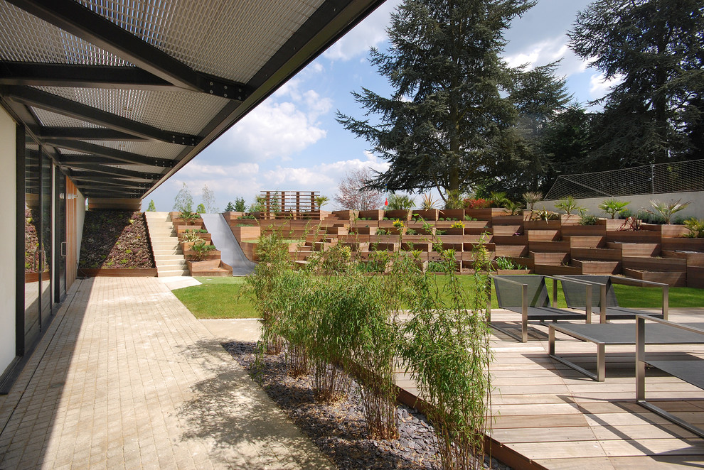 This is an example of a large contemporary sloped full sun outdoor sport court for spring in London with decking.