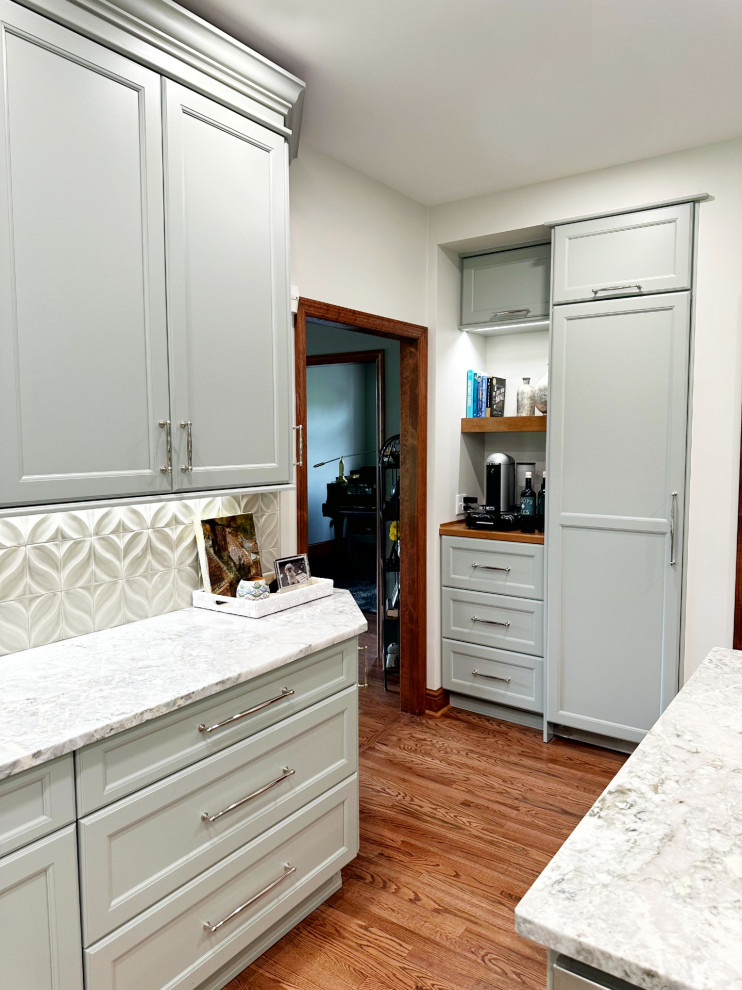Transitional l-shaped medium tone wood floor eat-in kitchen photo with shaker cabinets, green cabinets, quartzite countertops, porcelain backsplash, paneled appliances and an island
