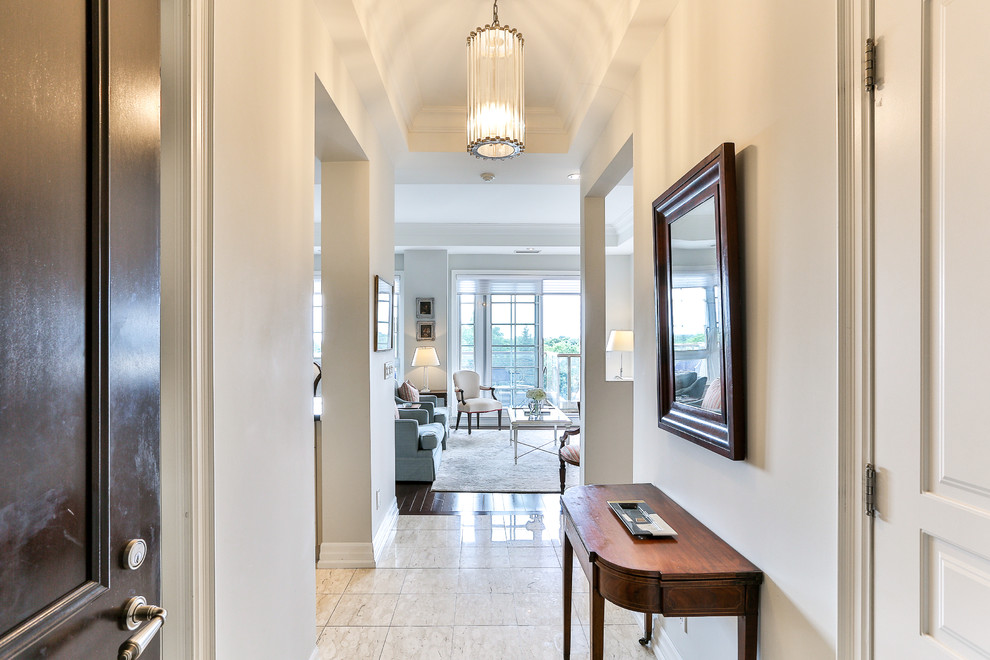 Photo of a mid-sized transitional foyer in Toronto with beige walls, porcelain floors, a single front door, a dark wood front door and beige floor.