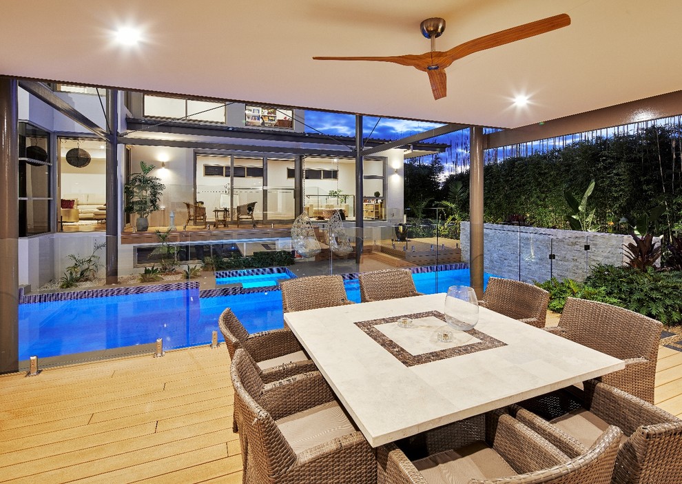Photo of a mid-sized beach style backyard patio in Sydney with decking and a roof extension.