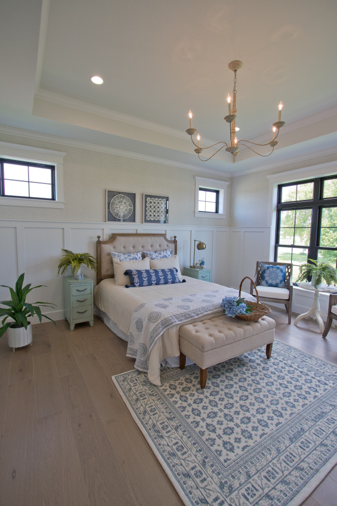 This is an example of a master bedroom in Other with light hardwood floors, brown floor, coffered and decorative wall panelling.