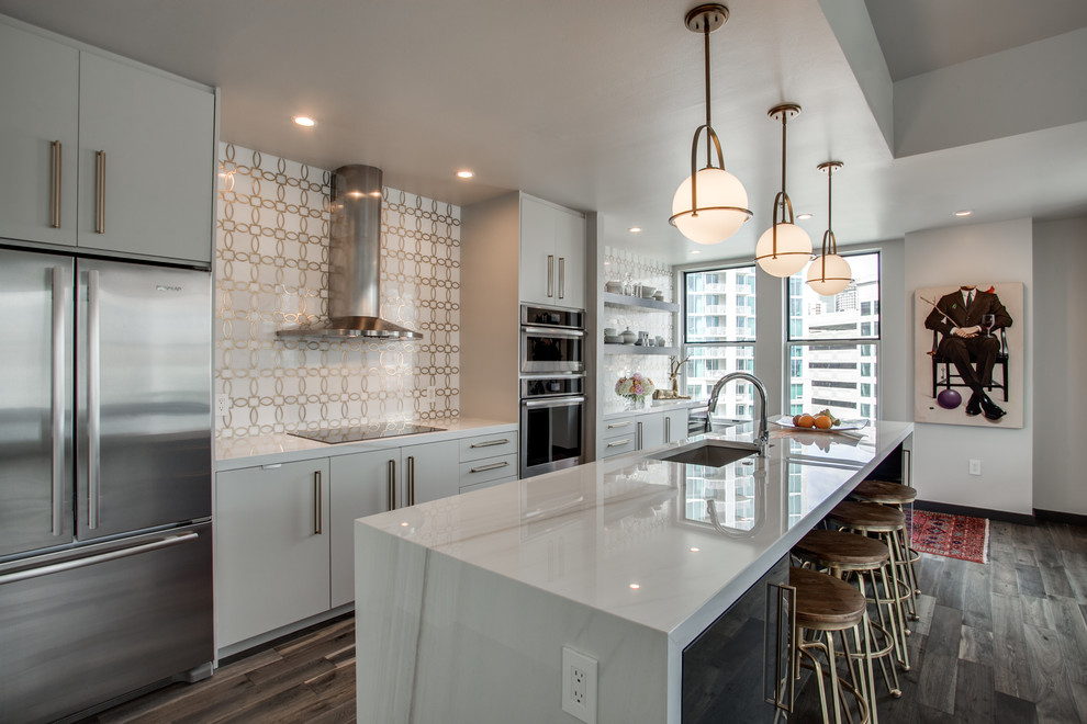Inspiration for a contemporary galley eat-in kitchen in Dallas with an undermount sink, flat-panel cabinets, white cabinets, solid surface benchtops, metallic splashback, porcelain splashback, stainless steel appliances, with island, brown floor, white benchtop and dark hardwood floors.