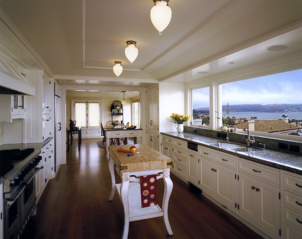 Design ideas for a traditional kitchen in San Francisco with panelled appliances, a double-bowl sink and white cabinets.