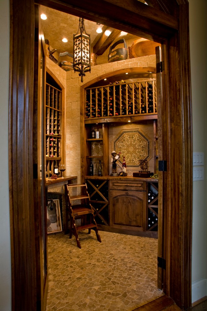Inspiration for a mid-sized mediterranean wine cellar in Other with travertine floors and storage racks.
