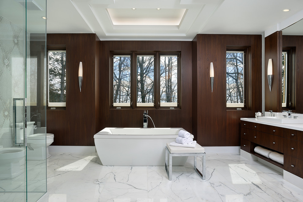 This is an example of a large contemporary master bathroom in Toronto with a drop-in sink, flat-panel cabinets, dark wood cabinets, a freestanding tub, a corner shower, a two-piece toilet, multi-coloured tile, mosaic tile, brown walls and marble floors.