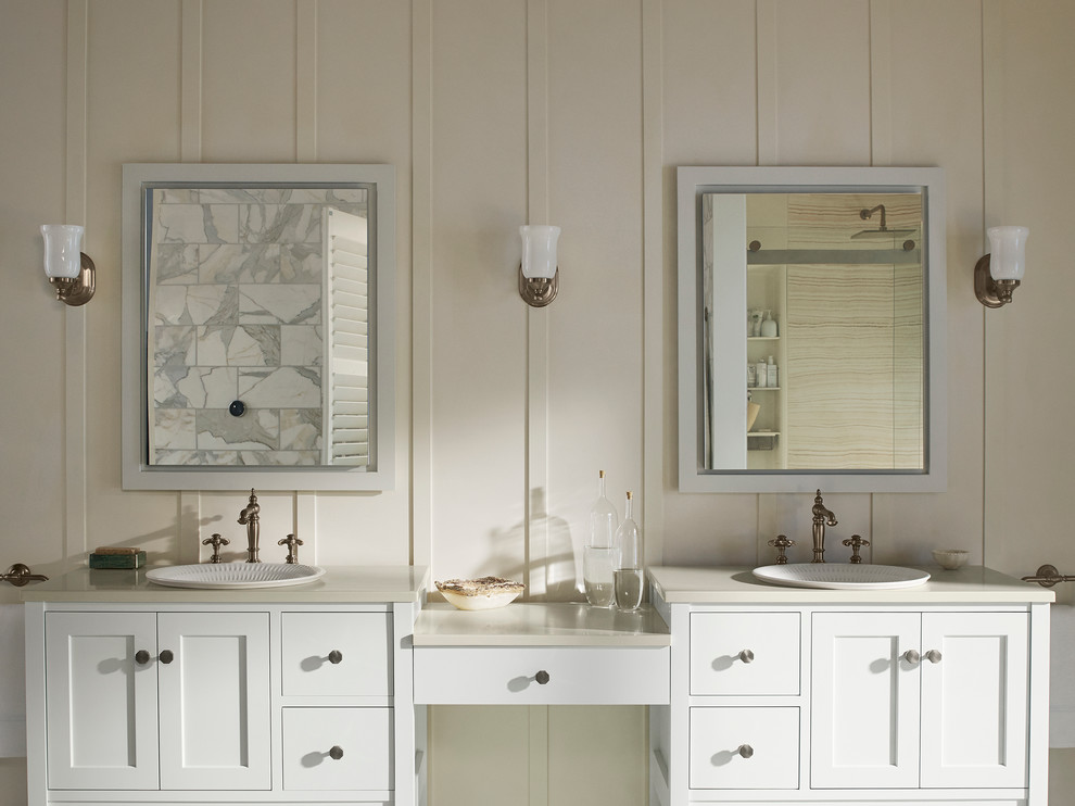 Inspiration for a mid-sized beach style master bathroom in Minneapolis with recessed-panel cabinets, white cabinets, white tile, stone tile, white walls, a drop-in sink and solid surface benchtops.