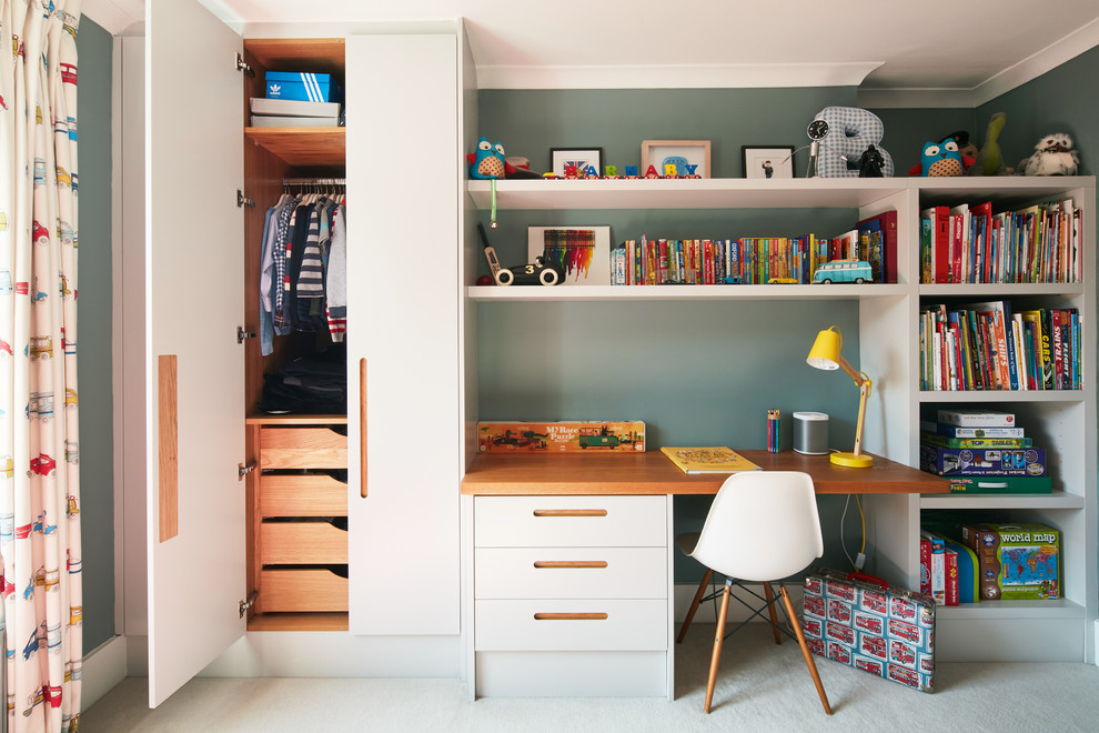 This is an example of a mid-sized contemporary gender-neutral kids' bedroom for kids 4-10 years old in London with blue walls and carpet.