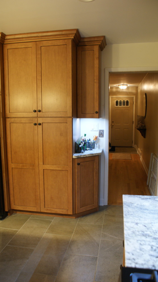 Enclosed kitchen - mid-sized transitional u-shaped porcelain tile enclosed kitchen idea in Chicago with an undermount sink, shaker cabinets, medium tone wood cabinets, granite countertops, multicolored backsplash, glass sheet backsplash, stainless steel appliances and a peninsula