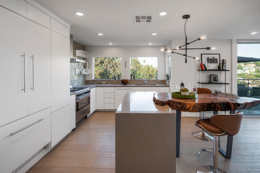 Design ideas for a mid-sized contemporary l-shaped kitchen in Los Angeles with an undermount sink, flat-panel cabinets, white cabinets, brown splashback, matchstick tile splashback, panelled appliances and with island.