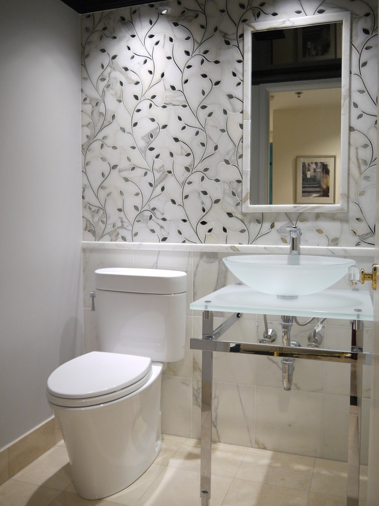 This is an example of a small eclectic powder room in Boston with a vessel sink, glass benchtops, a two-piece toilet, white tile, stone tile, grey walls and marble floors.