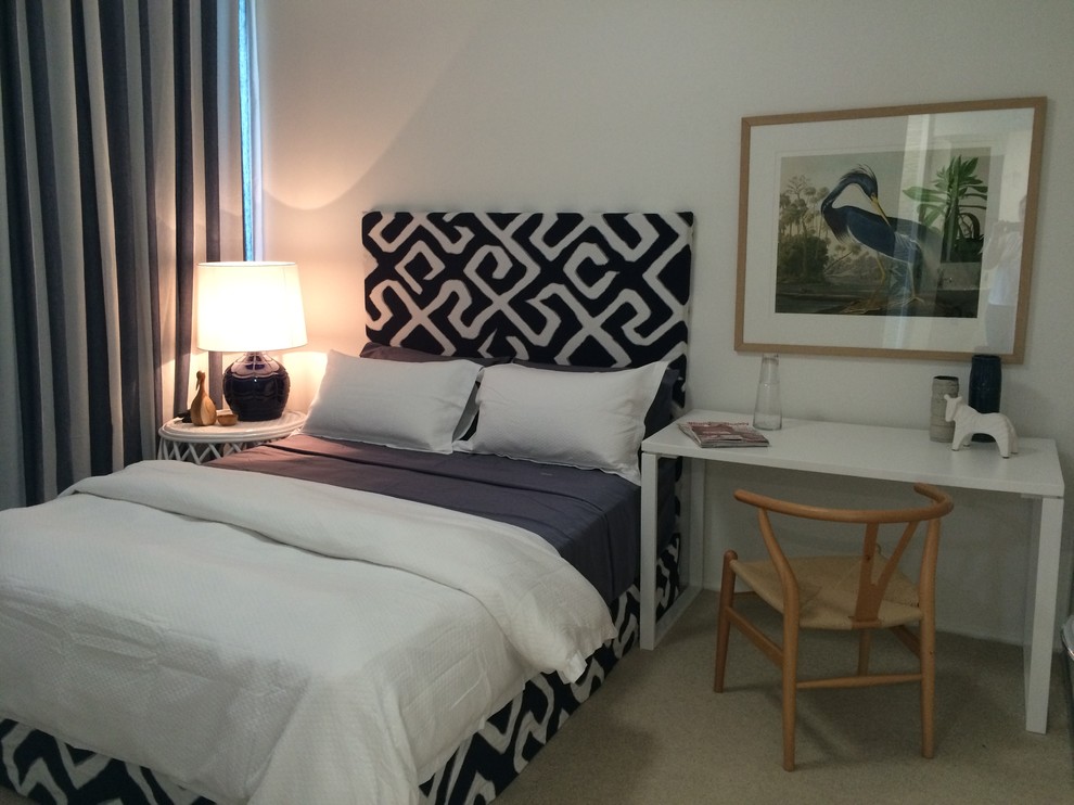 Mid-sized beach style guest bedroom in Townsville with carpet.