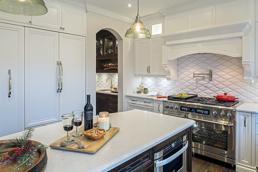 Mid-sized transitional l-shaped enclosed kitchen photo in Toronto with white cabinets, quartz countertops and an island