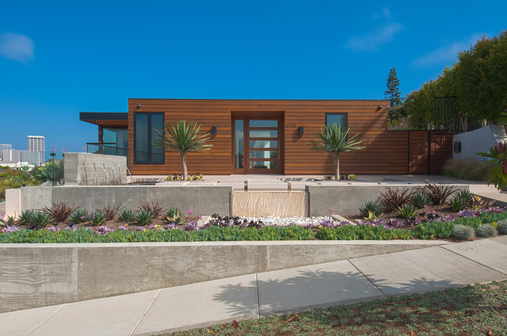 Photo of a contemporary one-storey exterior in Orange County with wood siding and a flat roof.