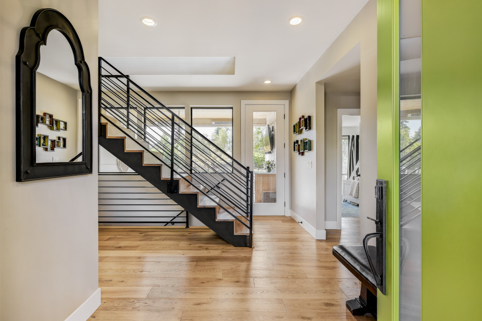 Photo of a mid-sized transitional foyer in Seattle with beige walls, light hardwood floors, a single front door and a green front door.