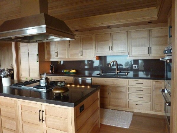 Large contemporary l-shaped eat-in kitchen in Seattle with an undermount sink, light wood cabinets, onyx benchtops, black splashback, stainless steel appliances, medium hardwood floors and with island.