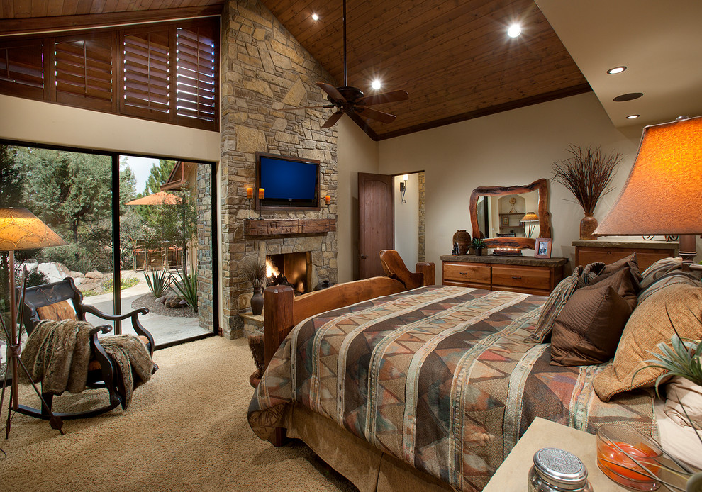 Mid-sized country master bedroom in Phoenix with beige walls, carpet, a standard fireplace and a stone fireplace surround.