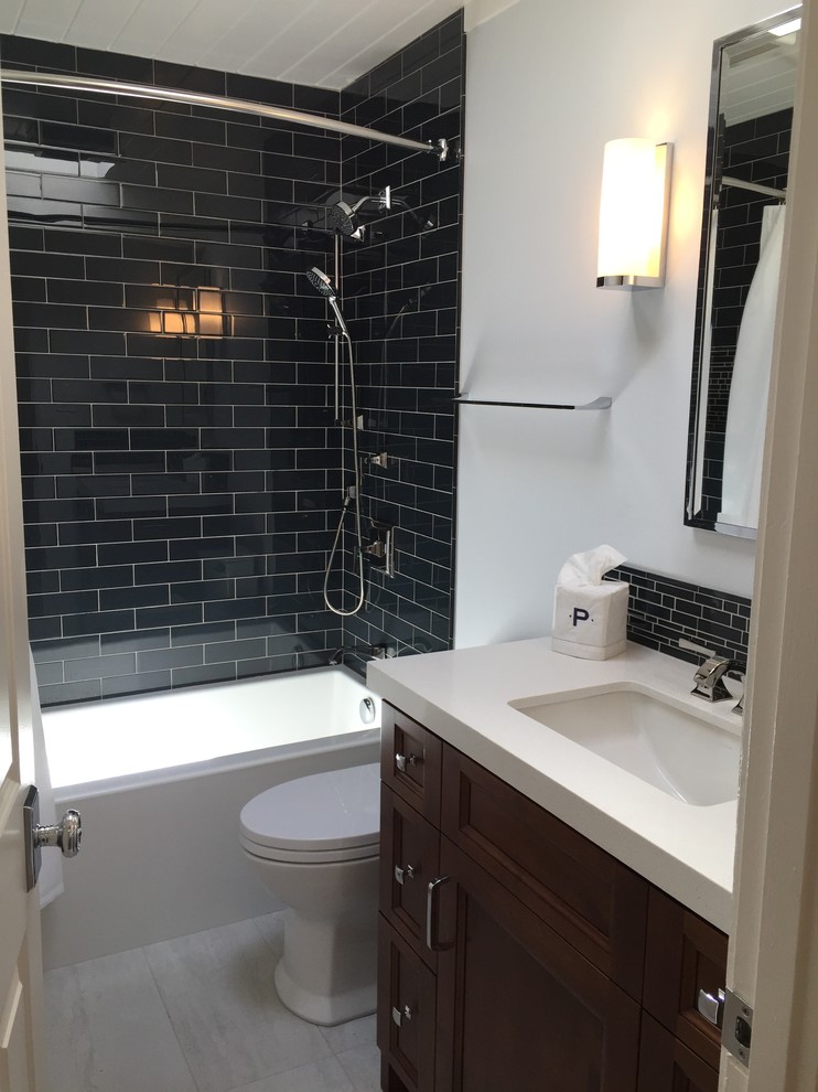 Inspiration for a small midcentury bathroom in San Francisco with recessed-panel cabinets, dark wood cabinets, an alcove tub, a shower/bathtub combo, a one-piece toilet, blue tile, glass tile, grey walls, ceramic floors, an undermount sink and engineered quartz benchtops.