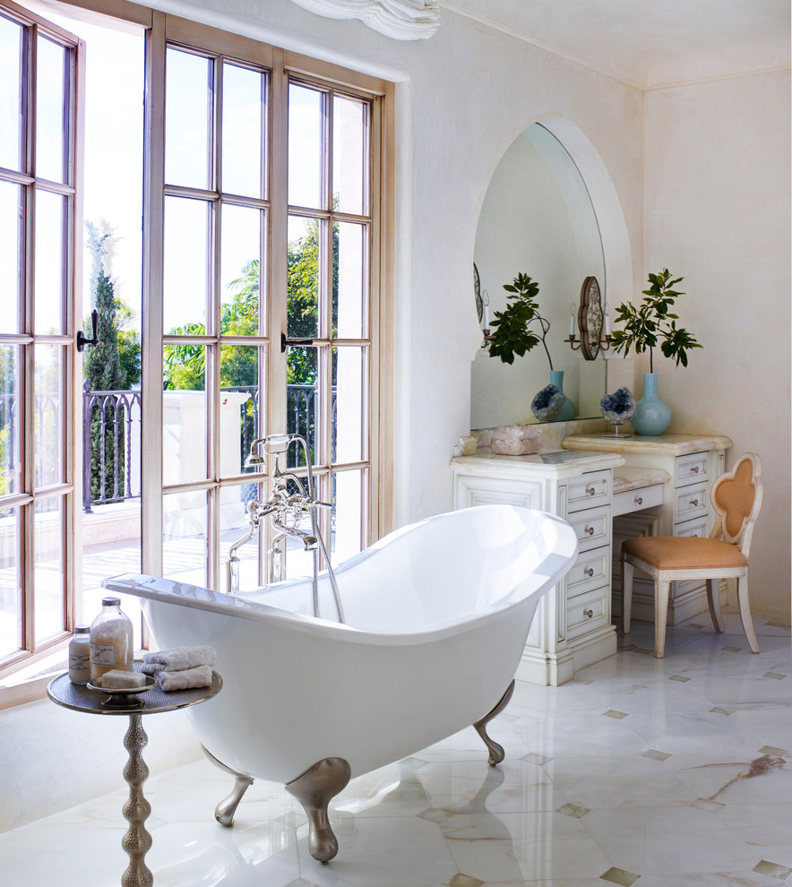 Inspiration for an expansive mediterranean master bathroom in Orange County with white cabinets, a claw-foot tub, white walls, marble floors, limestone benchtops, multi-coloured floor and recessed-panel cabinets.