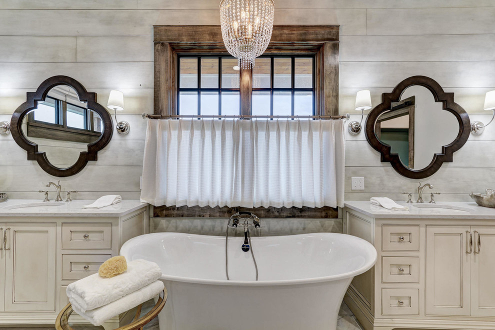 Design ideas for a country master bathroom in Oklahoma City with beaded inset cabinets, beige cabinets, a freestanding tub, grey walls and an undermount sink.