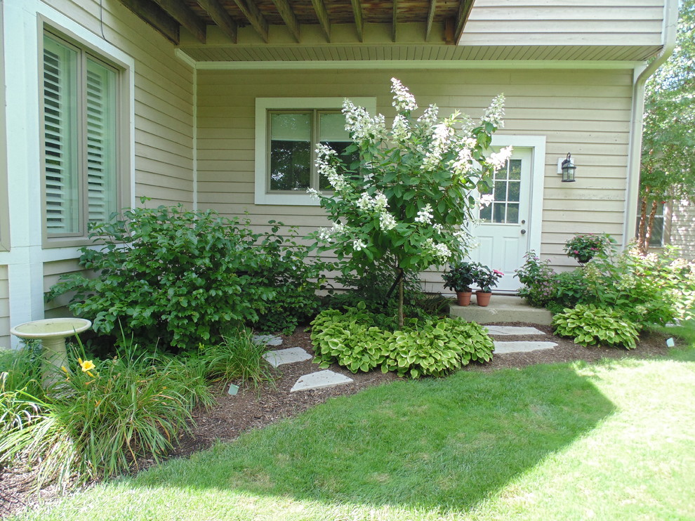 This is an example of a mid-sized traditional backyard partial sun garden in Chicago with with flowerbed and mulch.