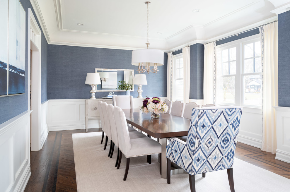 Transitional dining room in New York with blue walls, dark hardwood floors and brown floor.
