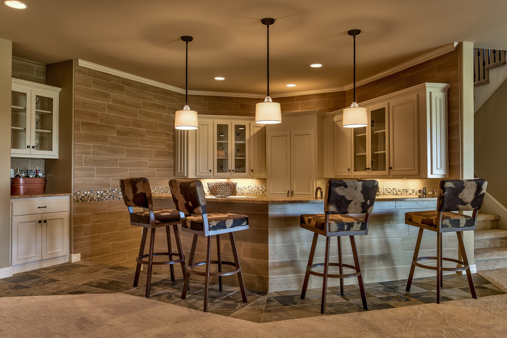 This is an example of a transitional u-shaped seated home bar in Omaha with carpet, recessed-panel cabinets and beige cabinets.