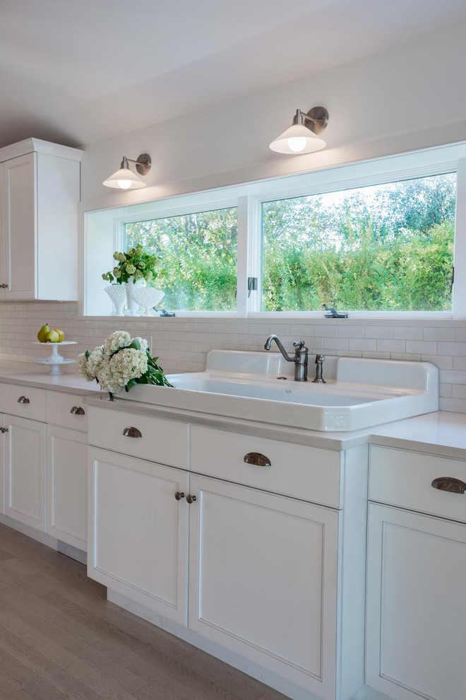 Design ideas for a traditional kitchen in New York with a farmhouse sink and white cabinets.