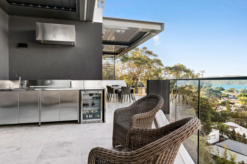 Large contemporary balcony in Sydney with a pergola and glass railing.