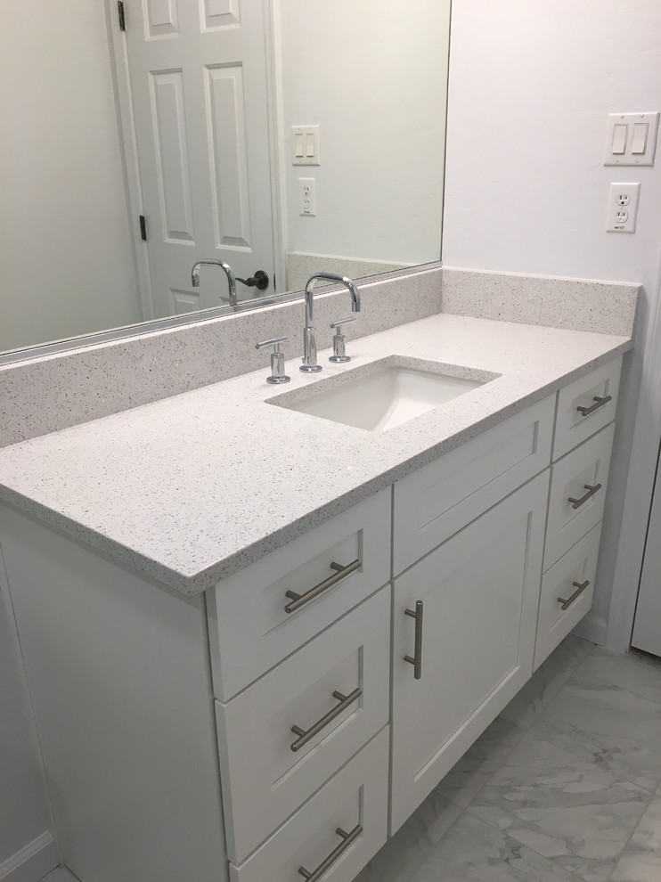 Inspiration for a mid-sized transitional white tile and ceramic tile ceramic tile bathroom remodel in Phoenix with recessed-panel cabinets, white cabinets, a one-piece toilet, white walls, an undermount sink and quartz countertops