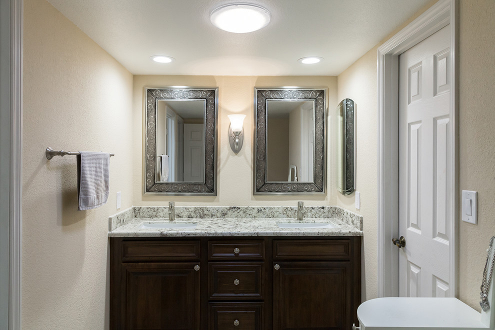 Mid-sized transitional master gray tile and porcelain tile porcelain tile and brown floor walk-in shower photo in Phoenix with shaker cabinets, dark wood cabinets, a one-piece toilet, beige walls, an undermount sink, granite countertops and beige countertops