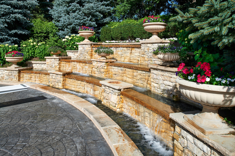 Inspiration for a large traditional backyard full sun garden in Denver with a water feature and concrete pavers.