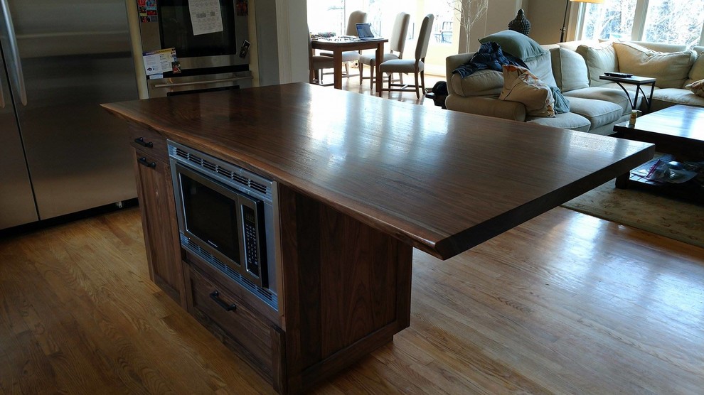 Walnut and mid-sized mountain style wood and l-shaped medium tone wood floor and brown floor open concept kitchen photo in DC Metro with a microwave shelf, an undermount sink, beaded inset cabinets, dark wood cabinets, wood countertops, beige backsplash, ceramic backsplash, stainless steel appliances and an island