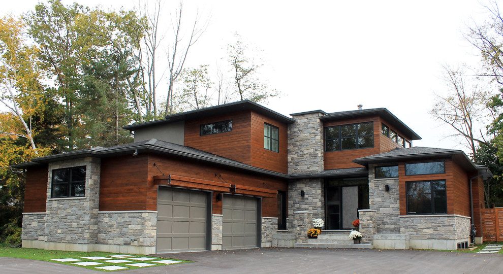 This is an example of a contemporary exterior in Toronto with wood siding and a hip roof.