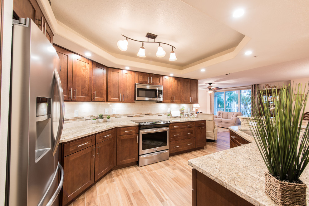 Mid-sized transitional u-shaped porcelain tile and beige floor eat-in kitchen photo with an undermount sink, shaker cabinets, dark wood cabinets, granite countertops, beige backsplash, stone tile backsplash, stainless steel appliances and an island