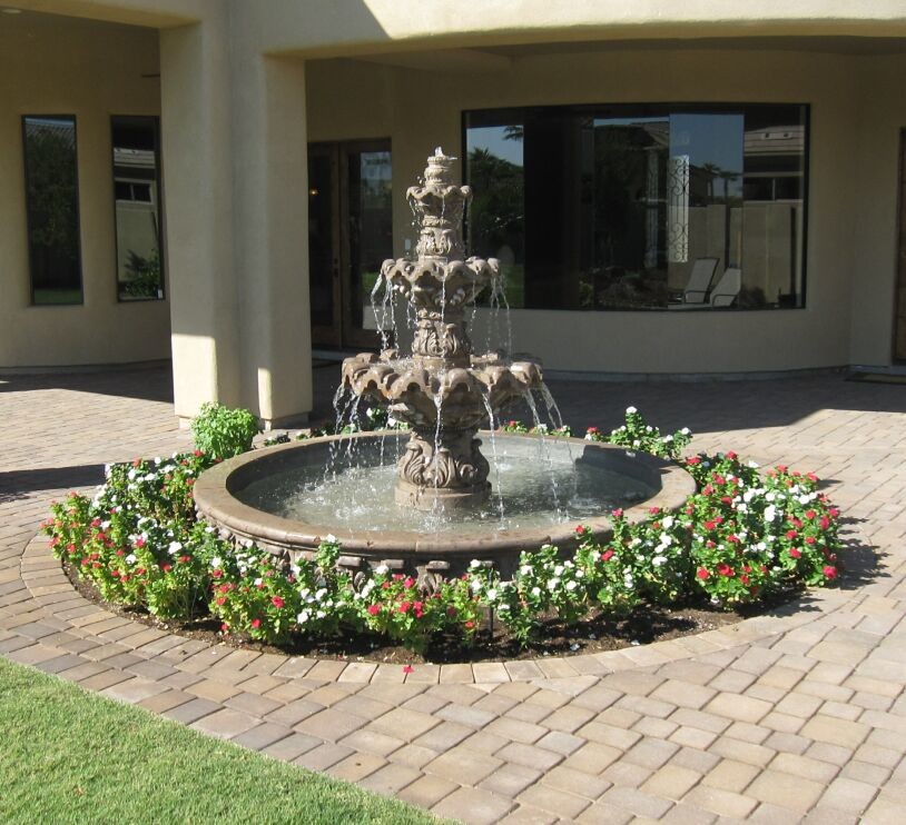Large mediterranean courtyard formal garden in Phoenix with a water feature and natural stone pavers.
