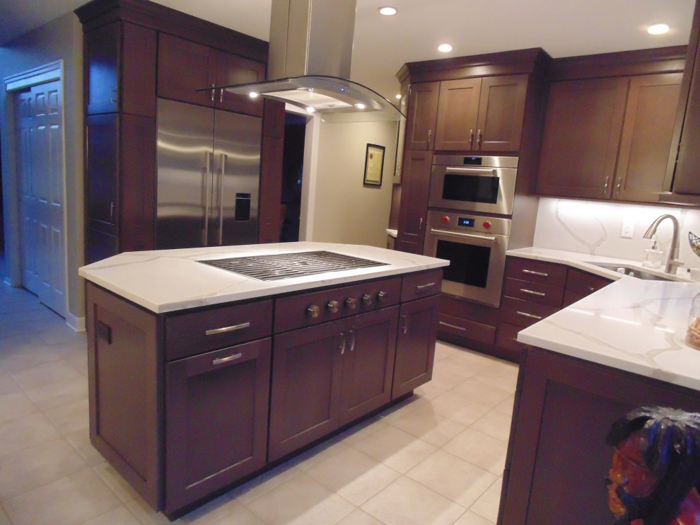 Example of a mid-sized transitional u-shaped ceramic tile and beige floor eat-in kitchen design with an undermount sink, recessed-panel cabinets, dark wood cabinets, quartz countertops, white backsplash, stone slab backsplash, stainless steel appliances, an island and white countertops